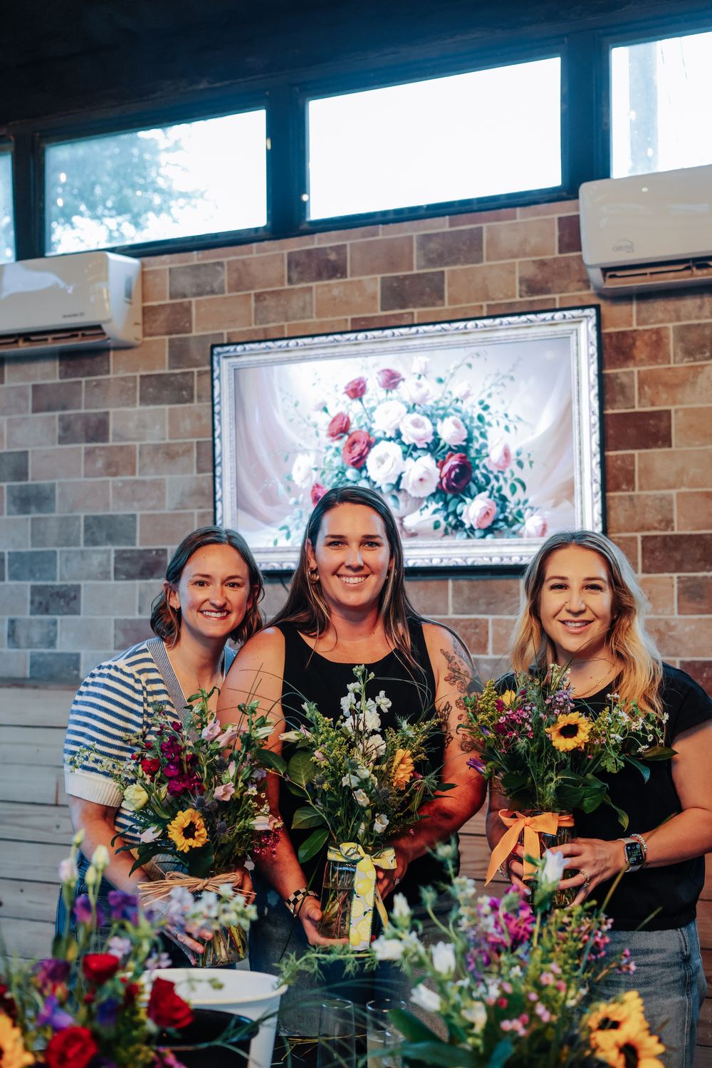 Guests holding floral arrangements at a private workshop event
