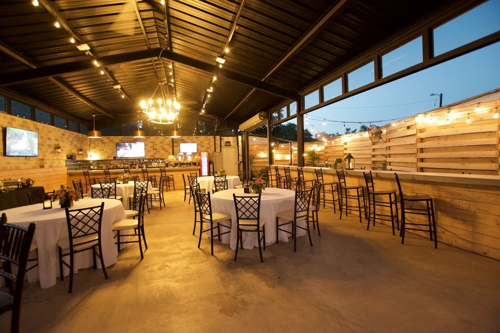 Event space set with linened tables under warm string lights